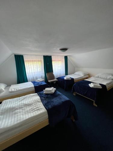 um quarto de hotel com três camas com lençóis azuis em 7Rooms em Telnice