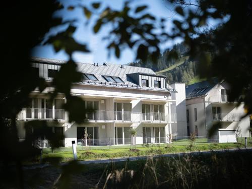 a large white building with solar panels on it at BASECAMP Reiteralm in Schladming