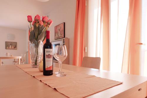 a bottle of wine sitting on a table with a glass at CASA NAVLA' AppartamentI "Ulivi"- "Fiori" -"Velieri"-"Luna"-"Nido"-"Taverna" in Tignale