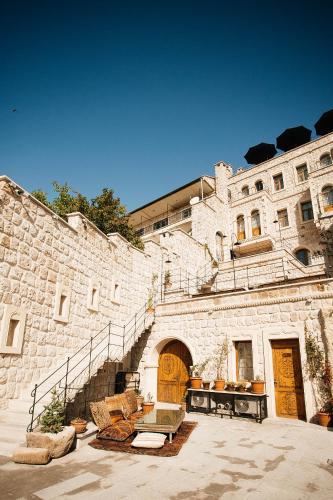 a stone building with stairs and a table and chairs at Cappadocia Vita Cave Hotel in Urgup