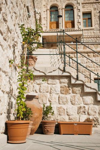 a stone building with three large vases with plants at Cappadocia Vita Cave Hotel in Urgup
