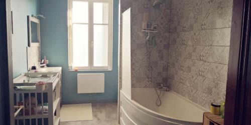 y baño con ducha, bañera y lavamanos. en Petit gîte ou chambre d'hôtes 2/4 personnes, en Buffières