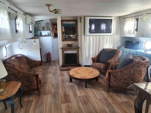 sala de estar con sillas, mesa y chimenea en PÉNICHE authentique tout confort, en Aigues-Mortes