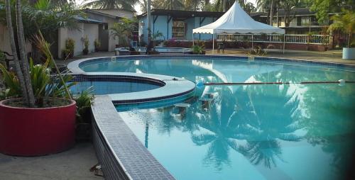 a large swimming pool with a tent in the background at PCB BEACH RESORT in Kota Bharu