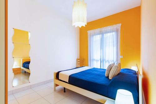 a bedroom with a blue bed and a yellow wall at Appartamento Minerva int3 - MyHo Casa in Tortoreto Lido