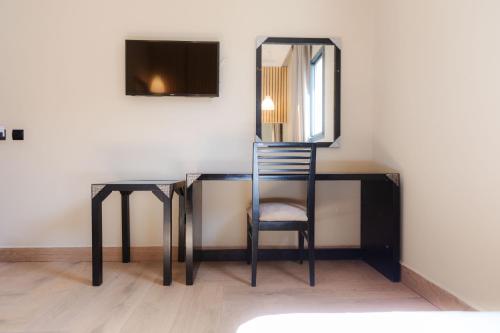 een bureau met een stoel en een spiegel aan een muur bij Ennesma Hotel in Casablanca