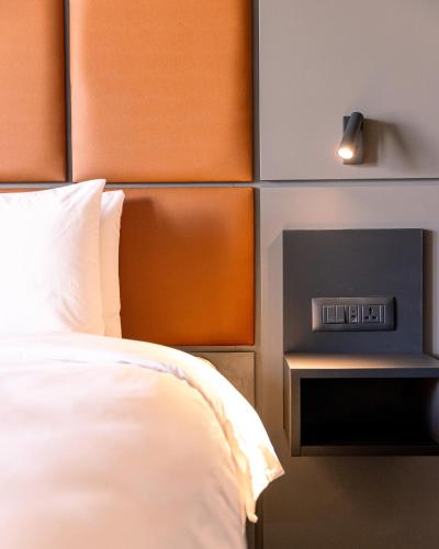 a bedroom with a bed and a clock on the wall at The Londoner Hotel St. Julian's in St Julian's