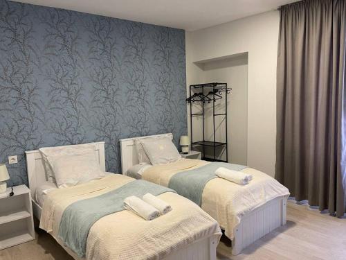 a bedroom with two beds and a blue wall at Guest House in Old Tbilisi in Tbilisi City