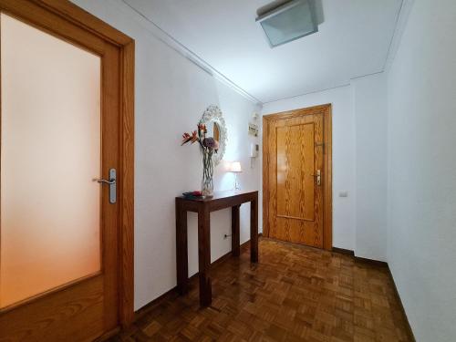 a hallway with a door and a vase of flowers on a table at Apartamento Balcón de la Luna in Benidorm