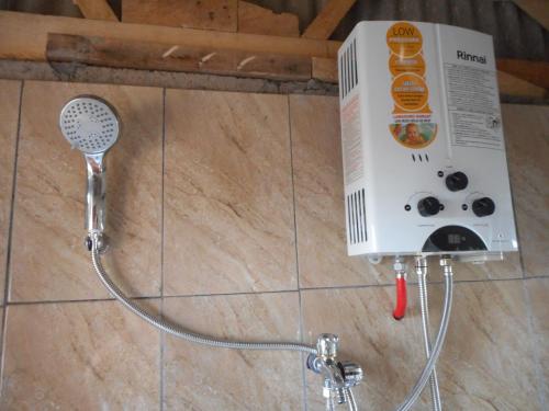 a shower head and a hair dryer on a wall at Candra Homestay Besakih in Besakih