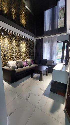 ein Wohnzimmer mit einem Sofa und einem Tisch in der Unterkunft New apartments in borjomi in Bordschomi