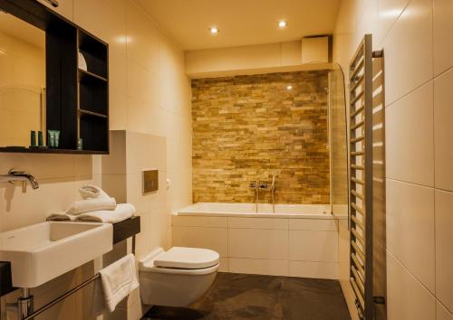 a bathroom with a toilet and a sink and a tub at Hotel Pałac Jugowice in Wałbrzych