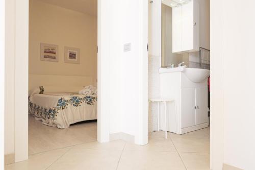 a room with a bed and a white room with a sink at CASA NAVLA' AppartamentI "Ulivi"- "Fiori" -"Velieri"-"Luna"-"Nido"-"Taverna" in Tignale