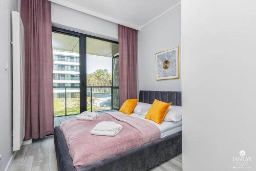 a bedroom with a bed and a large window at Shellter Apartments Villas - by Jantar Apartamenty in Rogowo