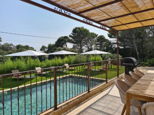 - une piscine entourée d'une clôture avec des chaises et des parasols dans l'établissement Villa de luxe en Luberon - Piscine chauffée, à Puget