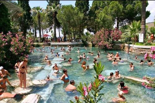 een groep mensen die zwemmen in een zwembad bij PRETTY HOUSE in Pamukkale