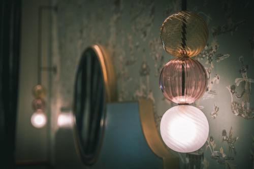 two lights on a table with a mirror on the wall at Hotel Giorgione in Venice
