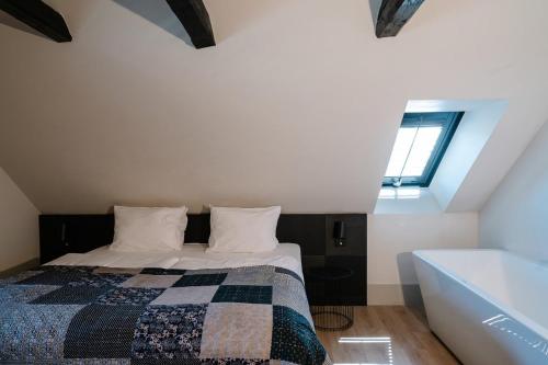 a bedroom with a bed and a window and a bath tub at Hotel Pałac Jugowice in Wałbrzych