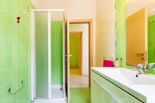 a green bathroom with a sink and a shower at Appartamento Minerva int2 - MyHo Casa in Tortoreto Lido