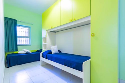 two beds in a room with green and yellow walls at Appartamento Minerva int2 - MyHo Casa in Tortoreto Lido