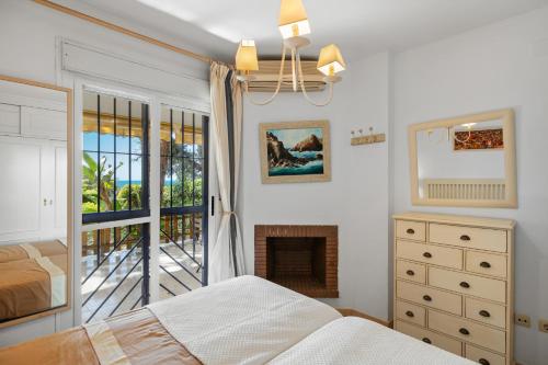 ein Schlafzimmer mit einem Bett und einem Kamin in der Unterkunft Seaview with private garden 5 minutes walk to the beach and amenities in Sitio de Calahonda