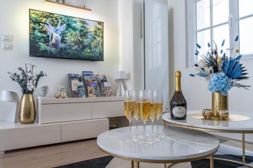 a living room with two glasses of wine on a table at Le Saint-Martin - PrestiPlace Tours in Tours