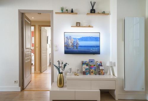 un salon avec une télévision sur un mur dans l'établissement Le Saint-Martin - Parking - PrestiPlace Collection, à Tours