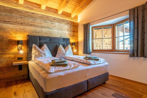 1 dormitorio con 1 cama con pared de madera en Apartment Taxer, en Aurach bei Kitzbuhel