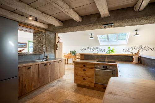 a kitchen with wooden cabinets and a counter top at grange rénovée en gîte/maison/chalet in Arreau