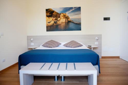Un dormitorio con una cama azul con un banco al lado en B&B Via delle 5 Terre, en La Spezia