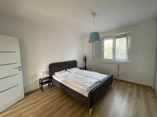 1 dormitorio con 1 cama grande en una habitación blanca en New Stylish City Center Apartment, en Komárno