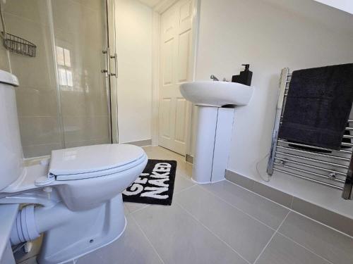 a white bathroom with a toilet and a sink at Bee Accommodations - Studio in Leicester
