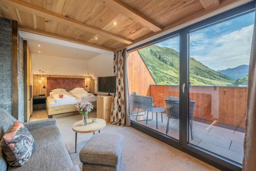 a room with a view of a bed and a balcony at Hotel Wiesental in Obergurgl