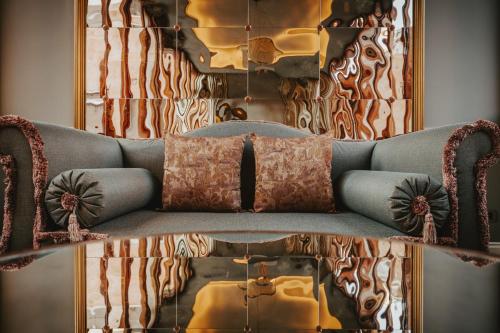 a living room with a blue couch and a mirror at Hotel Giorgione in Venice
