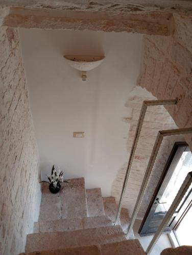 a staircase in a building with a potted plant at trullo Le murge in Alberobello