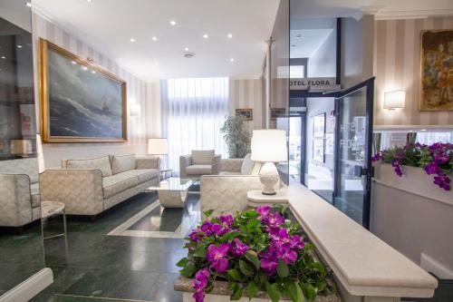 a living room with purple flowers on a table at Hotel Flora in Milan