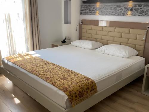 a bedroom with a large bed with white sheets at Puding Hotel in Antalya