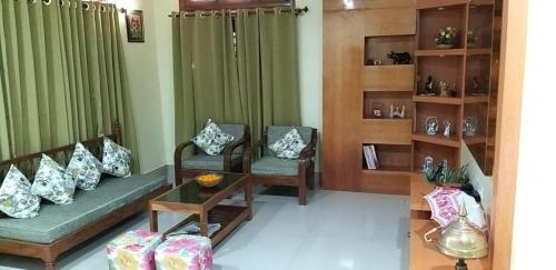 a living room with a couch and chairs and a table at Drizzle Homestay in Guwahati