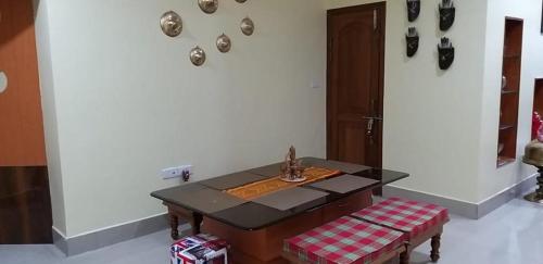 a room with a table and a bench and a wall at Drizzle Homestay in Guwahati
