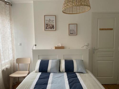 une chambre avec un lit avec une couverture rayée bleue et blanche dans l'établissement Maison de ville avec parking - Caen centre, à Caen