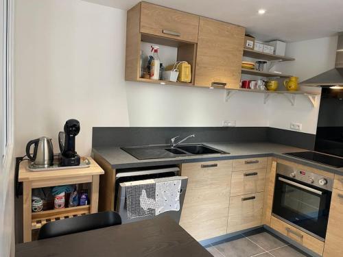a small kitchen with a sink and a stove at Maison de ville avec parking - Caen centre in Caen