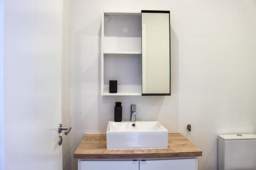 a bathroom with a white sink and a mirror at São Miguel Charming House by LFC Apts in Ponta Delgada