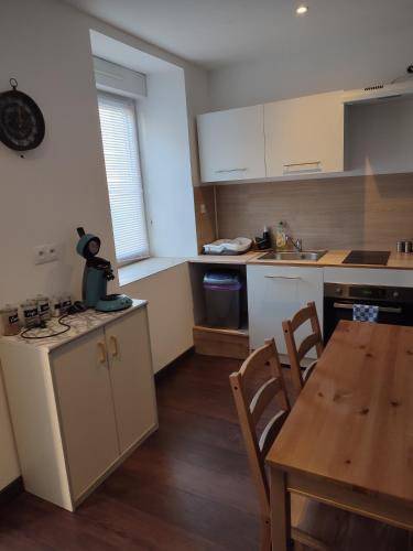 une cuisine avec une table en bois et une table ainsi qu'une salle à manger dans l'établissement Les deux via, à La Voulte-sur-Rhône