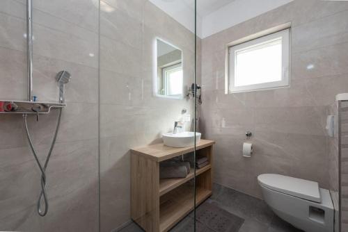Un baño con ducha, inodoro y lavabo. en Villa Paloma with pool, en Sukošan