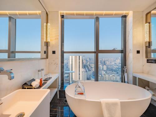 a bathroom with a tub and a large window at The Langbo Chengdu, in The Unbound Collection by Hyatt in Chengdu