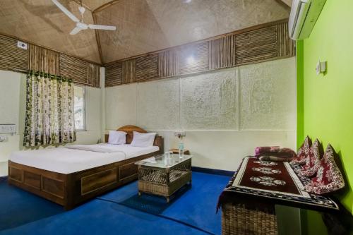 a bedroom with two beds and a chair in it at OYO Dooars Green Resort in Chālsa Mahābāri