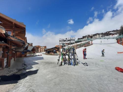 une station de ski avec un porte-skis dans la neige dans l'établissement Appartement carlines 1 les ménuires, aux Menuires