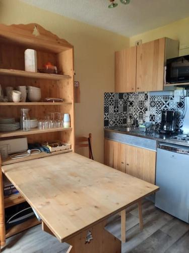 une cuisine avec une table en bois et un réfrigérateur dans l'établissement Appartement carlines 1 les ménuires, aux Menuires