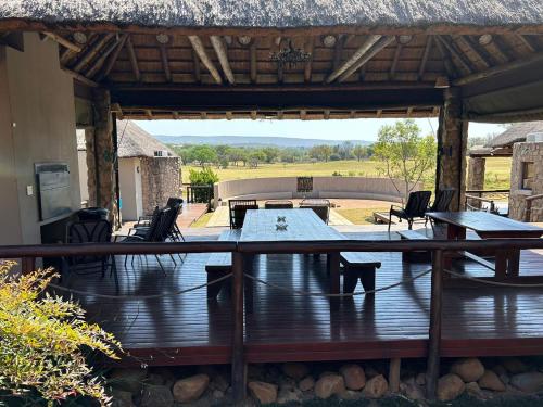 a patio with a table and chairs on a deck at 7th Hole Golf Lodge in Modimolle