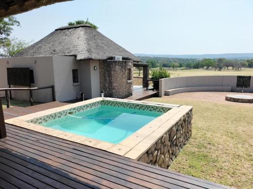 a swimming pool on the deck of a house at 7th Hole Golf Lodge in Modimolle